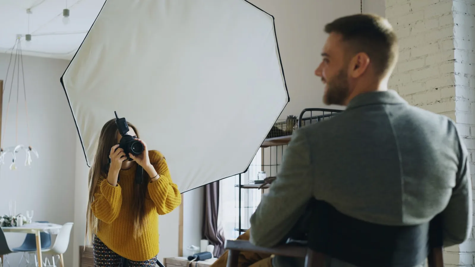 Fotografin fotografiert einen Mann im Sakko vor der Softbox